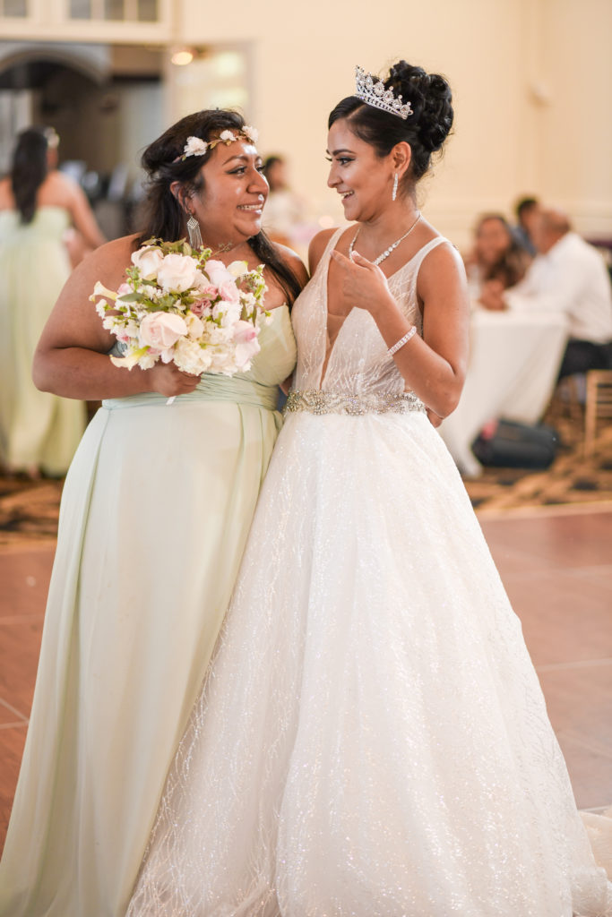 The bride poses with the bridesmaid who caught the bouquet