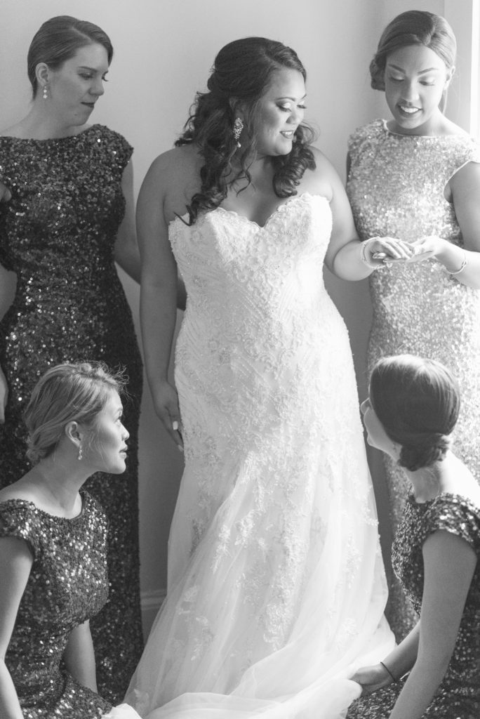 Bridesmaids help bride get ready before the wedding