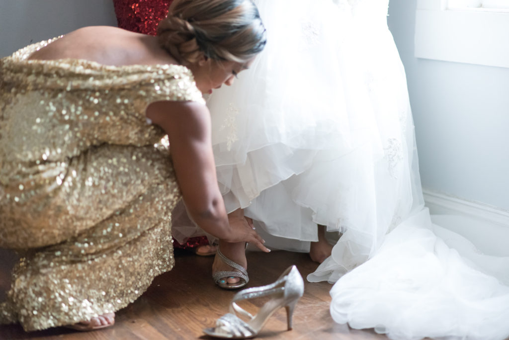 Bridesmaids help bride get ready before the wedding