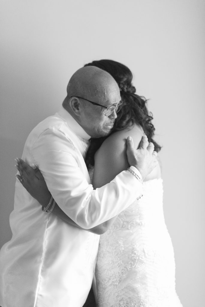 Bride's father gives her a hug after seeing her for the first time before her wedding