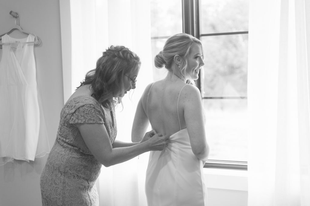 Mother of the bride helps bride get ready before her autumn wedding at Hazelwood Weddings