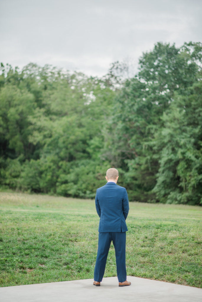 Groom waits for his bride during their first look at Hazelwood Weddings