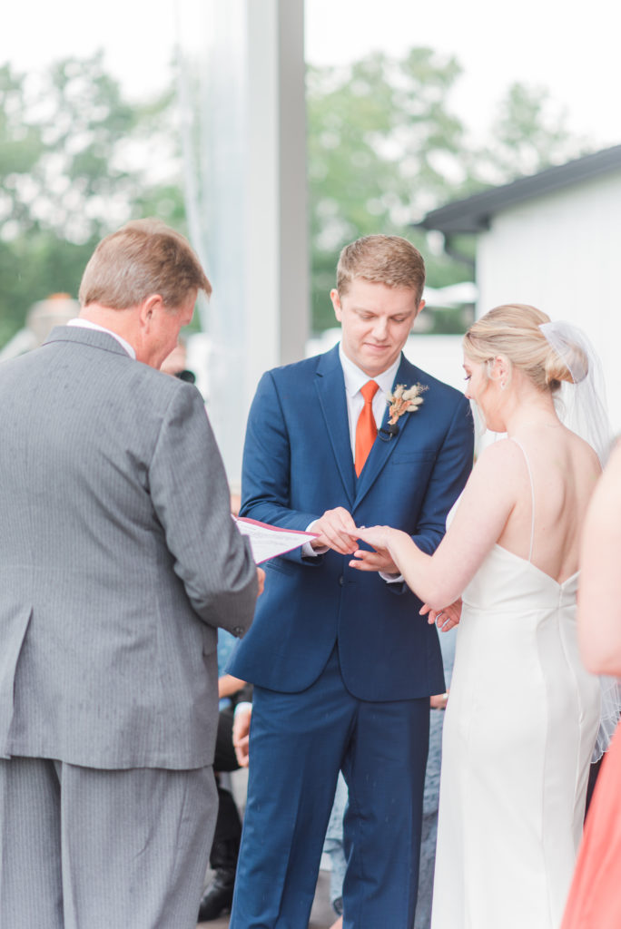 Bride and groom exchange rings at their wedding ceremony at Hazelwood Weddings