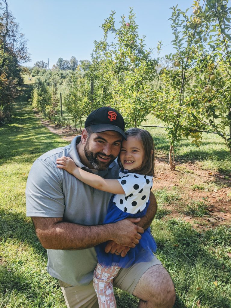 father and daughter picking apples 